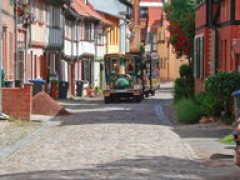 Die Bahn passiert die kleine Gasse hinter der Mauer